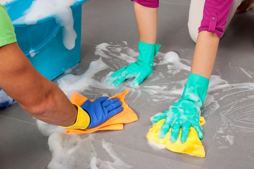 Cleaner placing safety measures around a damp floor during a job