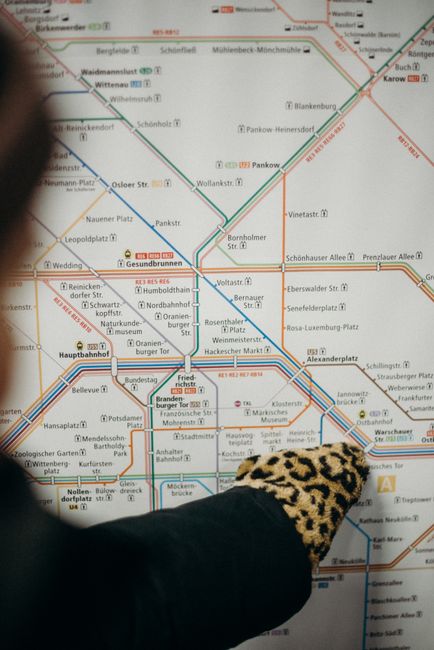 A clean and well-maintained underground train station platform with a curved concrete ceiling fitted with linear fluorescent lighting. The platform has a tiled surface featuring tactile strips near th